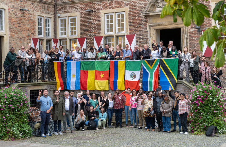 Foto de grupo delante del castillo de Oberwerries. En el medio están las banderas nacionales de los países participantes.